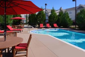 una piscina con sillas, mesas y una sombrilla roja en Residence Inn by Marriott San Antonio Airport/Alamo Heights en San Antonio