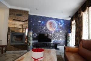 a living room with a tv and a fireplace at Hôtel Princesse Isabelle in Puteaux