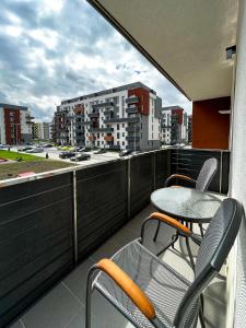 een balkon met een tafel en stoelen en uitzicht op de stad bij Alegria Avantgarden Brasov in Braşov