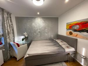 1 dormitorio con 1 cama y una pintura en la pared en Airport Rooms Waldblick, en Colonia