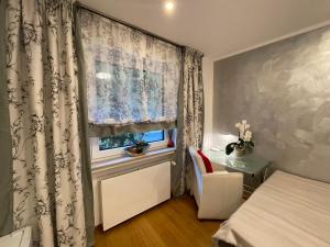 1 dormitorio con 1 cama y una ventana con cortinas en Airport Rooms Waldblick, en Colonia