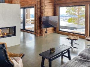 een woonkamer met een open haard en een televisie bij Holiday home Moen in Moen i Målselv