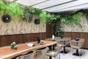 un restaurant avec une table, des chaises et un ordinateur portable. dans l'établissement Hotel Khla Nice, à Nice