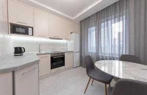 cocina blanca con mesa y comedor en Бориса Гмирі 20, 12 en Kiev