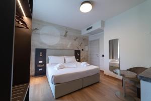 um quarto com uma grande cama branca e uma mesa em Hotel Arilica em Peschiera del Garda