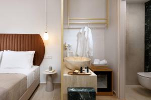 een slaapkamer met een bed, een wastafel en een bad bij Hotel Villa Natassa in Skala Rachoniou
