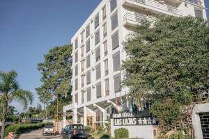 un edificio bianco con macchine parcheggiate di fronte di Gran Hotel Las Lajas a Villa Carlos Paz