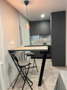 cocina con mesa y 2 sillas en una habitación en TK apartamenti en Rēzekne