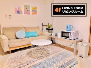 uma sala de estar com um sofá e um micro-ondas em Jen's House Osaka em Osaka
