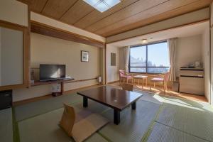 een woonkamer met een tafel en een groot raam bij Kirishima Hotel in Kirishima