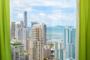 vista su una città con edifici e sull'oceano di Riu Plaza Panamá a Città di Panama