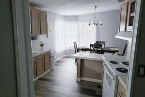 cocina con suelo de madera y encimera blanca en Country Quiet, en Sanford