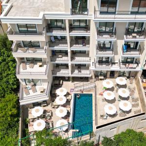 una vista aerea di un edificio con piscina e ombrelloni di Hotel Pima Budva a Budua