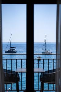 dos botes en el océano vistos desde una ventana en Hotel California by Aycon en Sveti Stefan