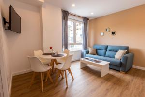 Maile Apartamentos في بوت: غرفة معيشة مع أريكة زرقاء وطاولة
