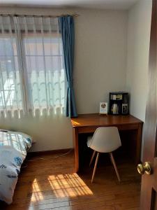 um quarto com uma secretária e uma cadeira ao lado de uma janela em Guest house with host Takao SORA- Vacation STAY 13000 em Hachioji