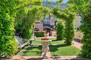 um jardim com uma fonte e bancos e árvores em BV Grand Hotel Assisi em Assisi