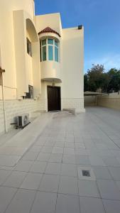 a large white building with a door and a courtyard at H5تشi in Madīnat Yanbu‘ aş Şinā‘īyah