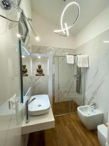 bagno bianco con lavandino e doccia di Marmore Charming House a Terni