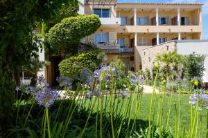 a building with purple flowers in front of it at Hôtel La Caravelle in Calvi