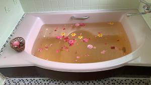 una bañera llena de flores rosas. en 旭日山荘 