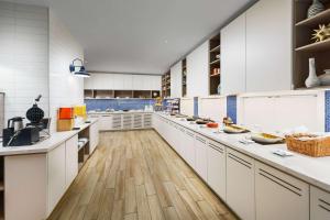 una grande cucina con armadi bianchi e pavimenti in legno di Hyatt Place Panama City Beach - Beachfront a Panama City Beach