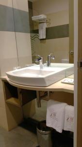 bagno con lavandino bianco e specchio di Isla Nova Hotel a Foz