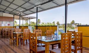 comedor con mesas y sillas de madera en Treebo vSaffron Regency, Punnamada Lake, en Alleppey