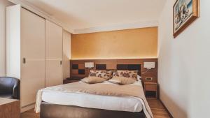 a bedroom with a large bed and two lamps at Hotel Cittar in Novigrad Istria