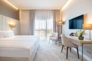 a hotel room with a bed and a desk at Hotel Gerardus in Szeged