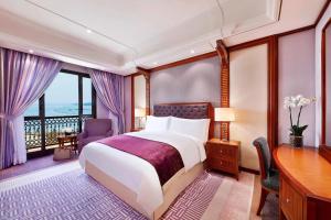 een hotelkamer met een bed, een bureau en een raam bij The Ritz-Carlton Jeddah in Jeddah