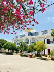 un edificio bianco con fiori rosa di fronte di Ninh Chu 2 Hotel a Phan Rang-Tháp Chàm