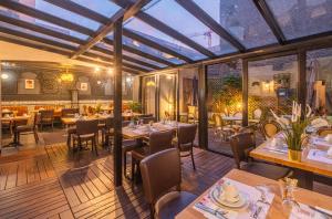 - une salle à manger avec des tables, des chaises et des fenêtres dans l'établissement The Originals Boutique, Hôtel Le Marignan,Le Havre Centre Gare, au Havre