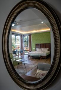un miroir reflétant une chambre avec un lit et un canapé dans l'établissement Tana Mysterious garden, à Panglao