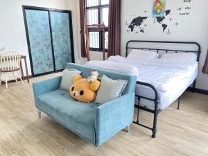 - une chambre avec un lit et une chaise avec un ours en peluche dans l'établissement Modern Loft Style, à Nakhon Phanom