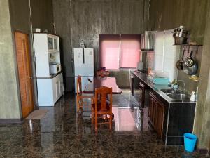 La cuisine est équipée d'une table, de chaises et d'un réfrigérateur. dans l'établissement Modern Loft Style, à Nakhon Phanom