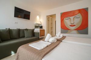 una sala de estar con sofá y una pintura de una mujer en 23 Hotel Mykonos, en Mykonos ciudad