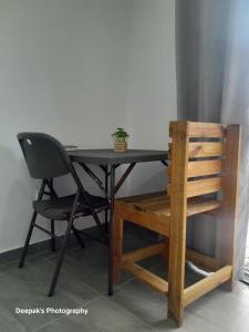 une table noire avec une chaise et une plante sur elle dans l'établissement Peace Hut, à Nadi