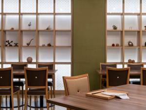 a restaurant with wooden tables and chairs and shelves at Mitsui Garden Hotel Kumamoto in Kumamoto