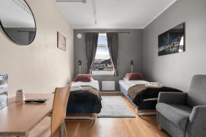 - une chambre avec deux lits, un bureau et une chaise dans l'établissement Enter Backpack Hotel, à Tromsø