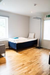 Landvetter Hotell في Härryda: غرفة نوم بسرير في غرفة ذات أرضيات خشبية