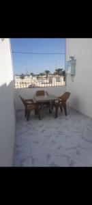 a patio with a table and benches on a balcony at Residence djerba 4 in Houmt Souk