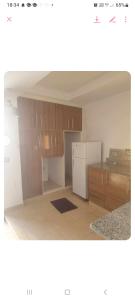 a kitchen with wooden cabinets and a white refrigerator at Residence djerba 4 in Houmt Souk