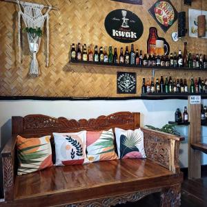 - un banc en bois dans un bar avec des bouteilles sur le mur dans l'établissement Hidden of Cailan Extension Transient House, à El Nido