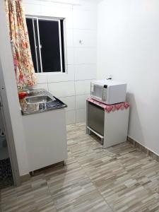 una piccola cucina con lavandino e forno a microonde di Apartamento Vila Telebrasilia a Brasilia