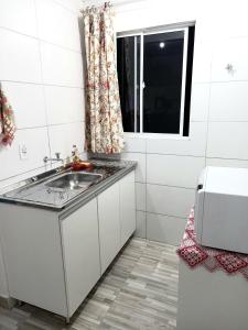 una piccola cucina con lavandino e finestra di Apartamento Vila Telebrasilia a Brasilia