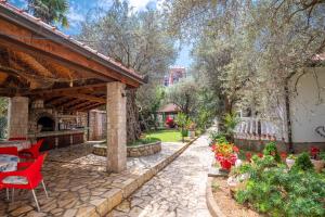 un patio in pietra con sedie rosse e un padiglione di President Bungalows and Apartments a Utjeha