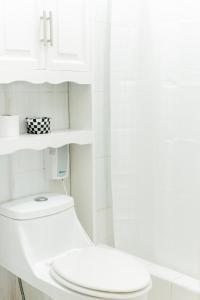 a white bathroom with a toilet and a sink at Hotel Villa del Lago in Flores