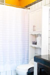 a bathroom with a white shower curtain and a toilet at Hotel Villa del Lago in Flores