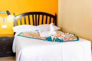 a swan sitting on top of a bed at Hotel Villa del Lago in Flores